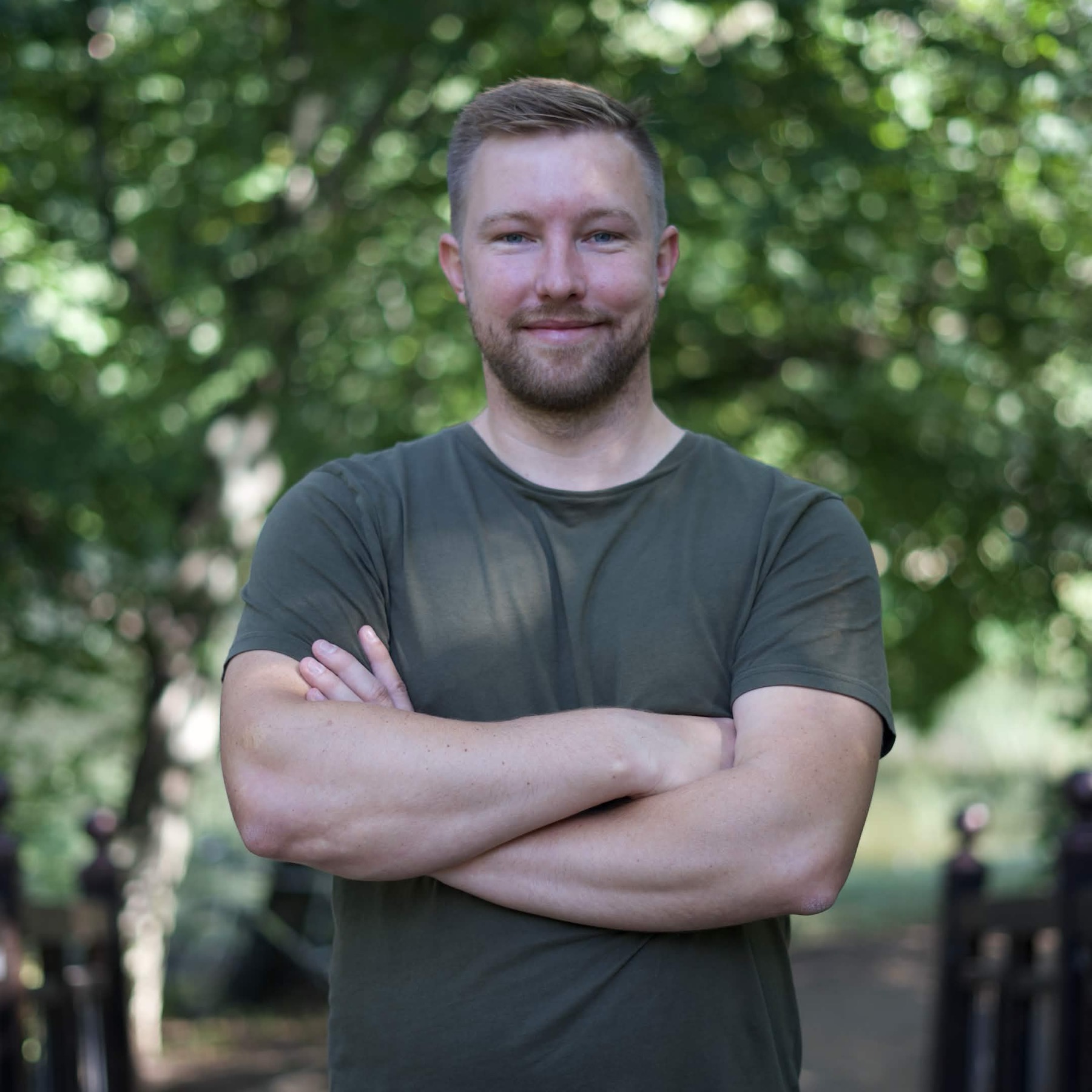 Thomas Brinkhaus, stehend im Grünen, Arme verschränkt